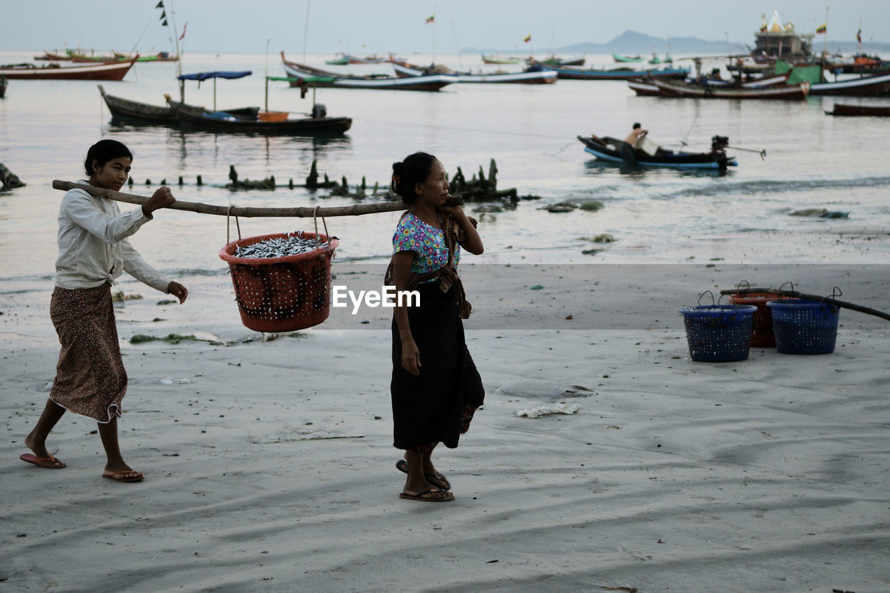 REAR VIEW OF PEOPLE ENJOYING IN BASKET