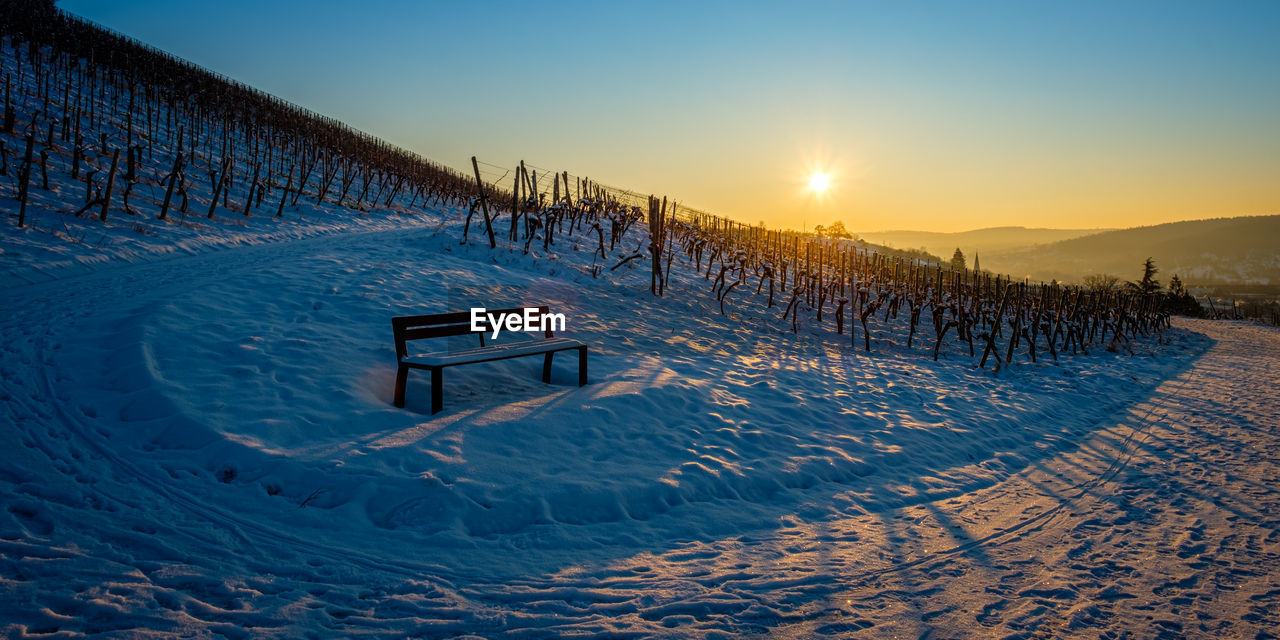 Scenic view of snow covered landscape against sky during sunset