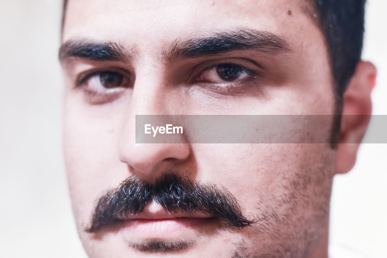 Close-up portrait of young man with mustache