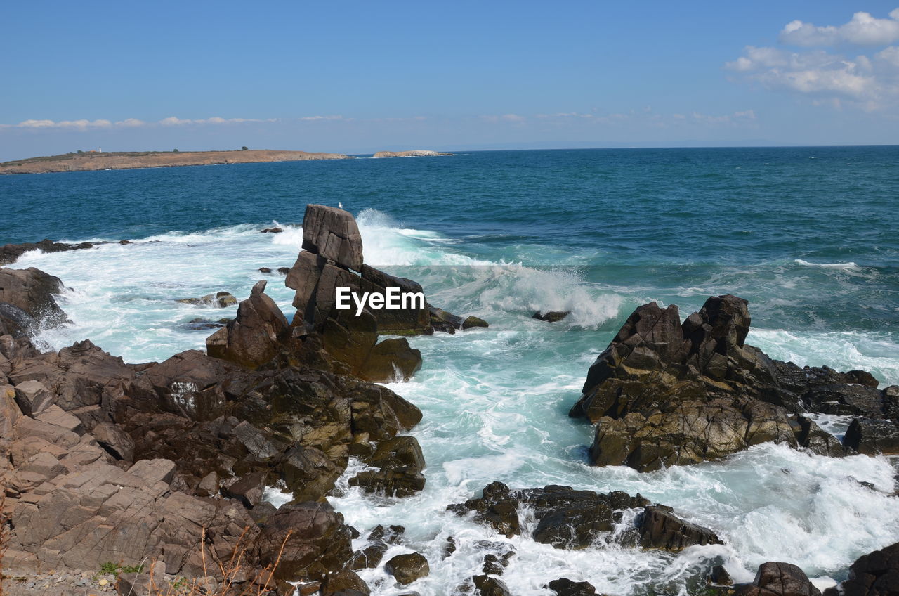 Scenic view of rocks in sea against sky