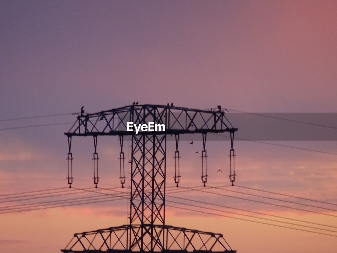 LOW ANGLE VIEW OF SILHOUETTE ELECTRICITY PYLON DURING SUNSET