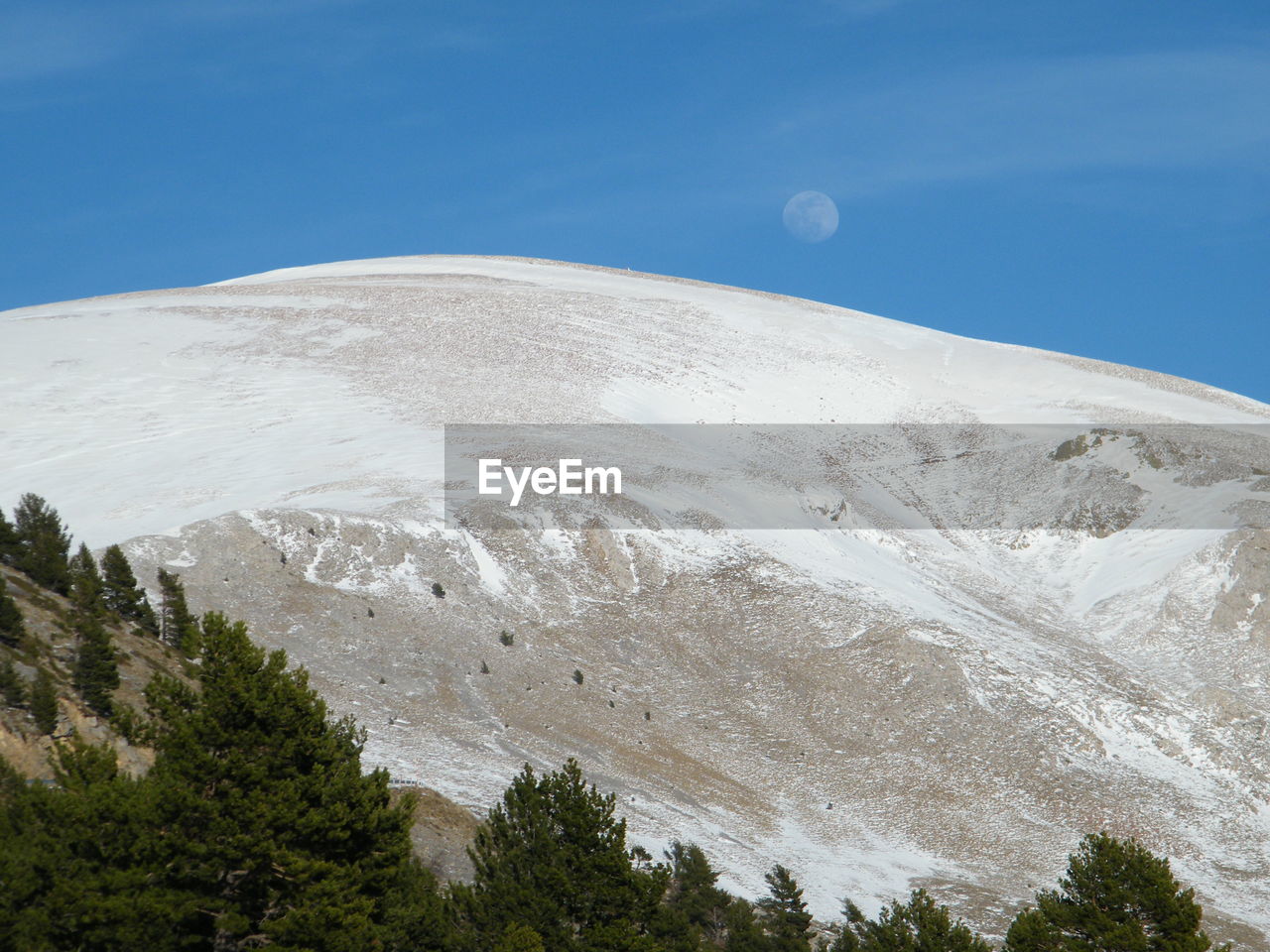 Moon over snowcapped mountain