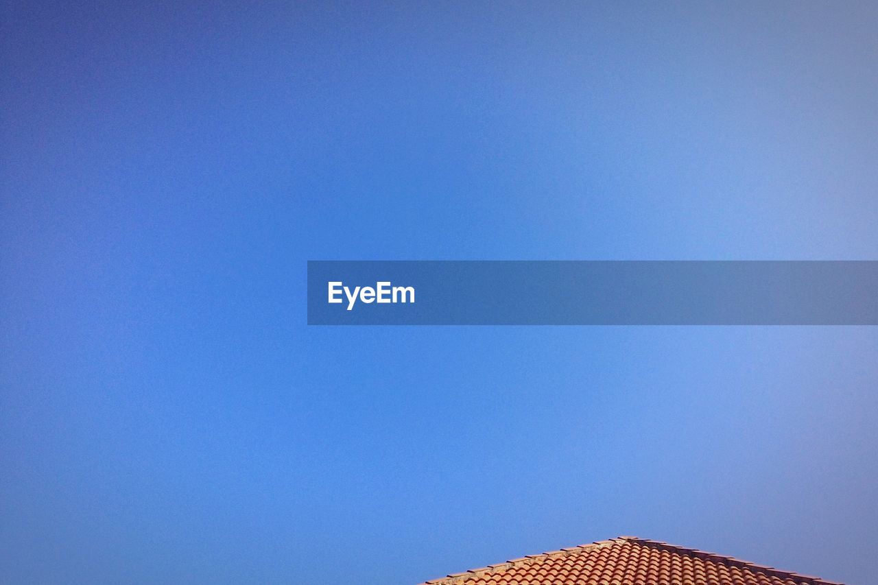 Low angle view of roof against clear blue sky