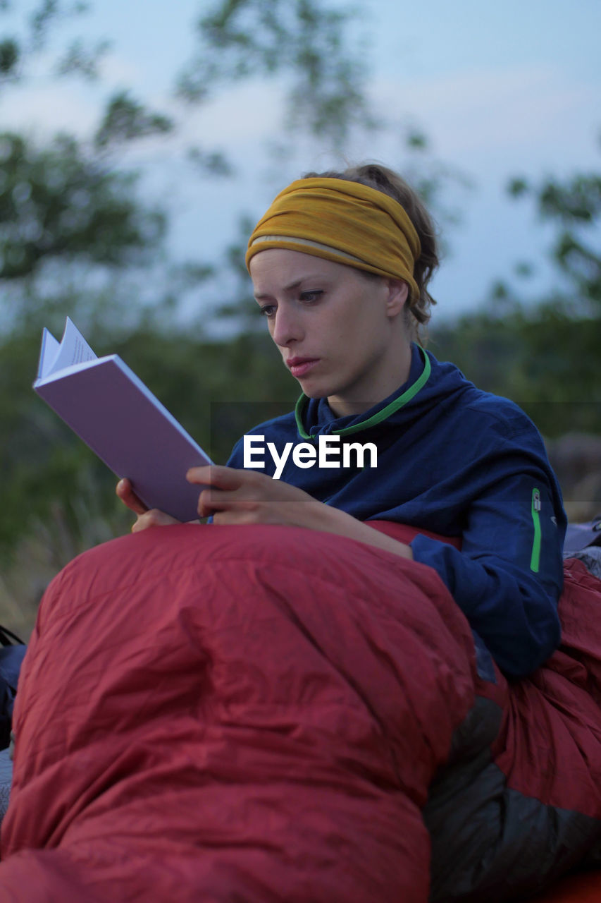 Woman wearing warm clothing while reading book