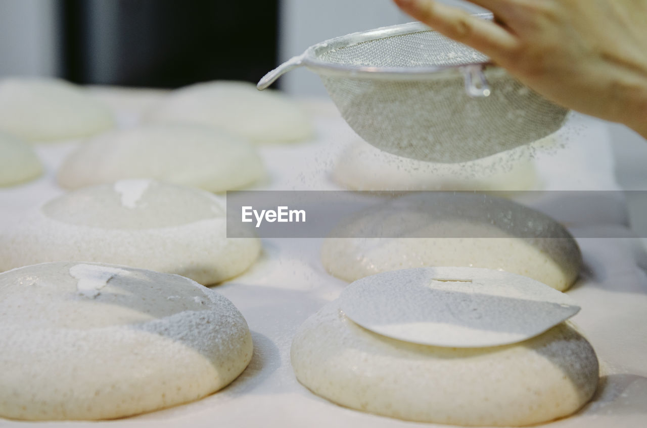 CLOSE-UP OF PERSON PREPARING FOOD IN KITCHEN