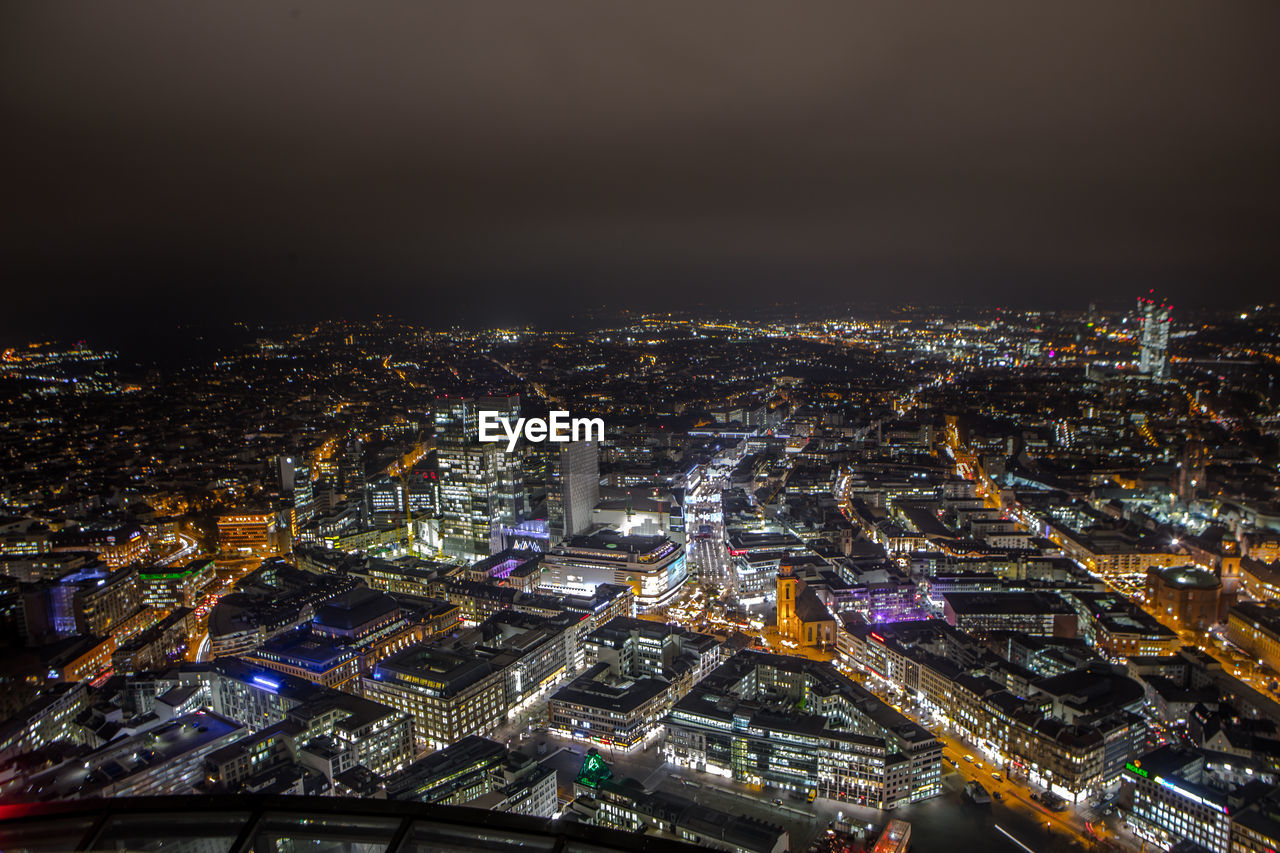 High angle view of illuminated cityscape against sky at night