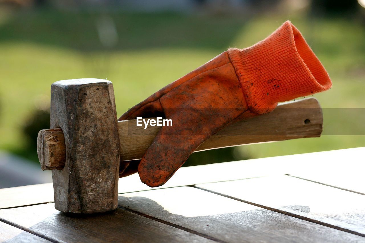 CLOSE-UP OF RUSTY METAL ON TABLE AGAINST WOODEN RAILING