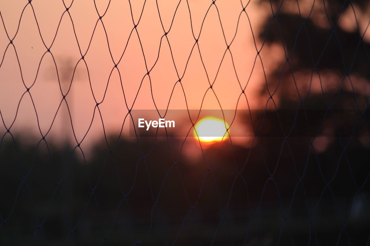 Close-up of fence during sunset