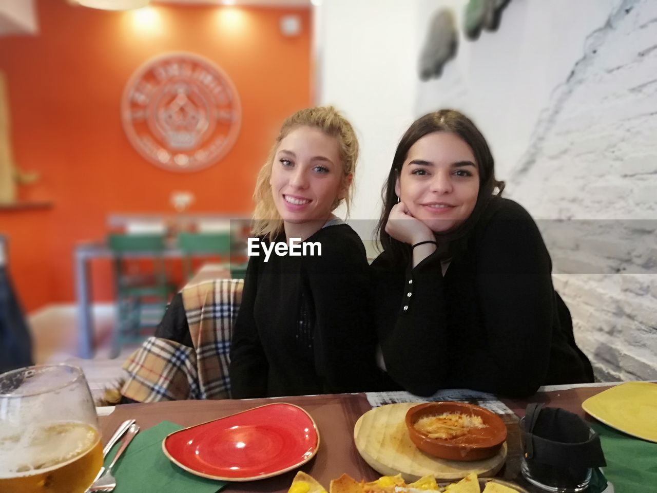 Portrait of smiling friends sitting at restaurant