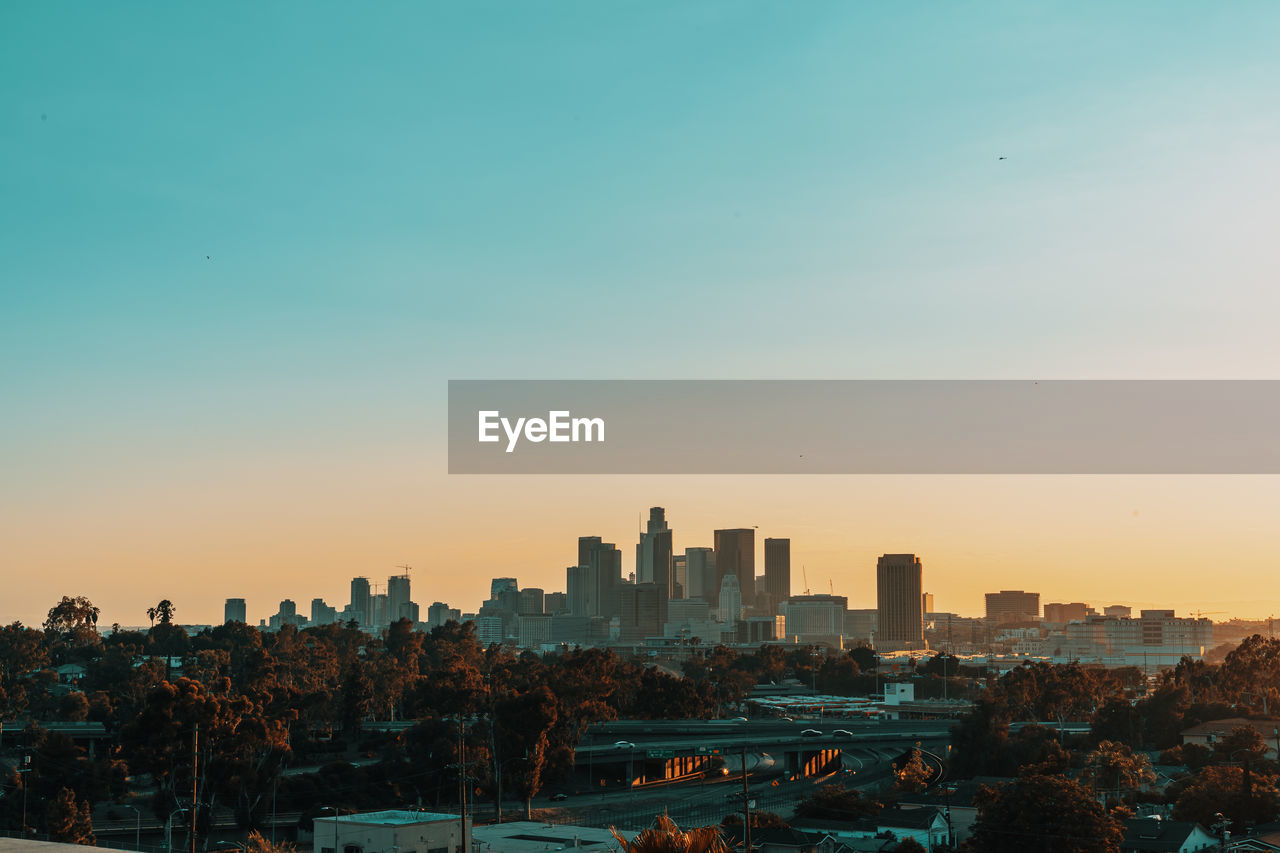 CITYSCAPE AGAINST SKY DURING SUNSET IN CITY