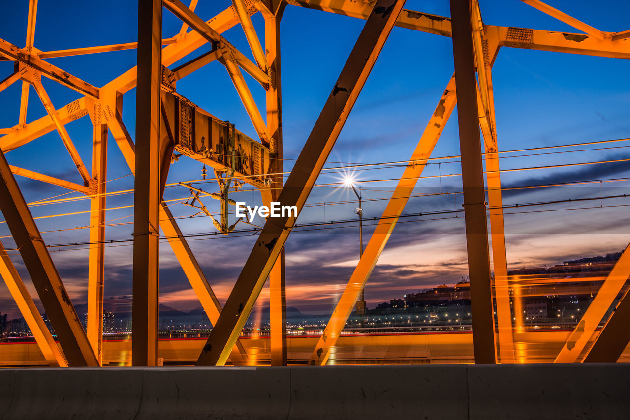 Low angle view of illuminated bridge against sky during sunset