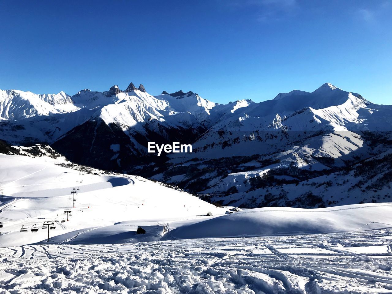 Scenic view of snowcapped mountains against clear blue sky