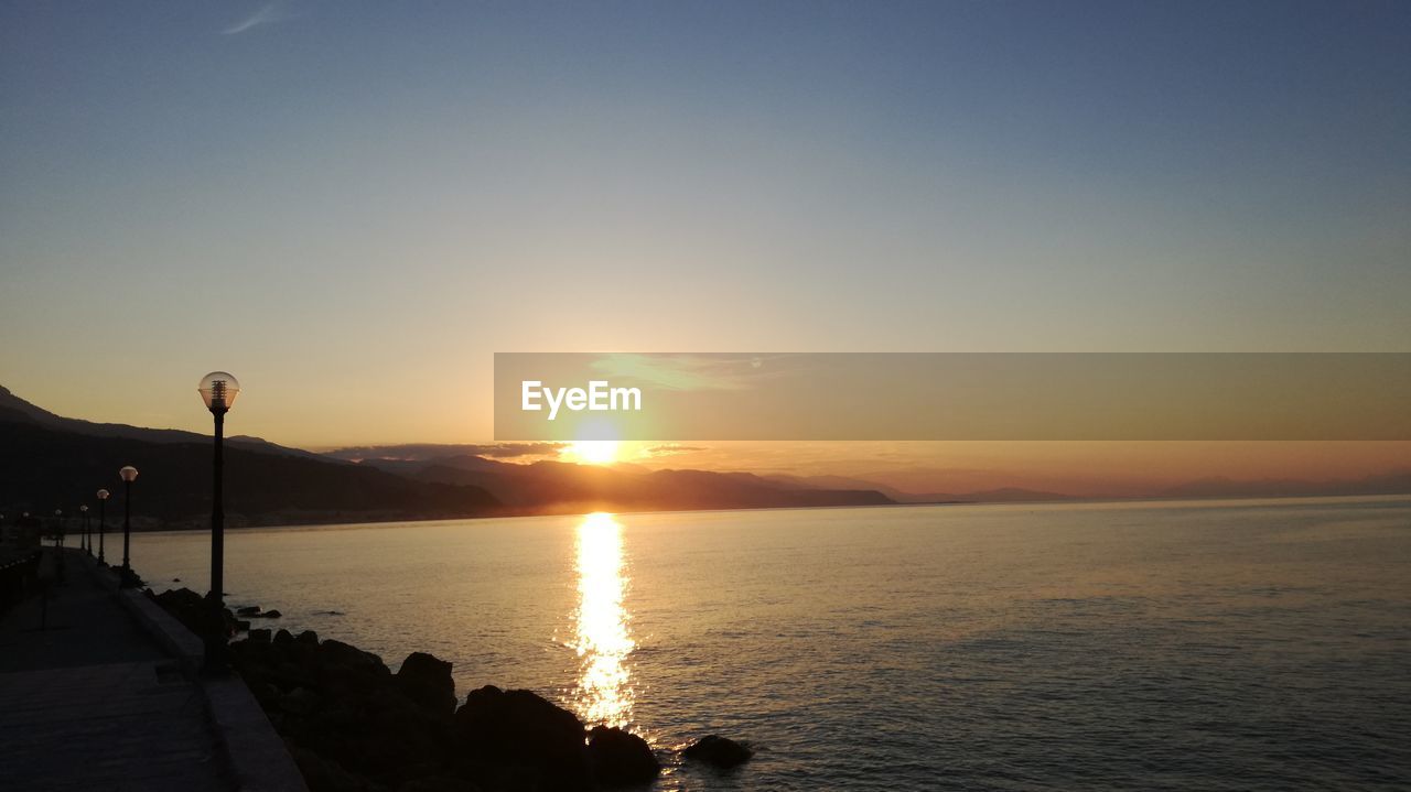 SCENIC VIEW OF SEA AT SUNSET