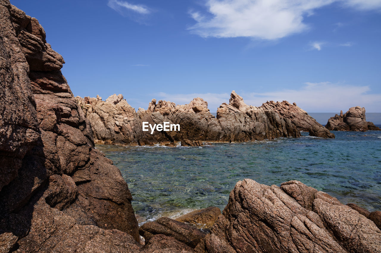 ROCKS ON BEACH AGAINST SKY