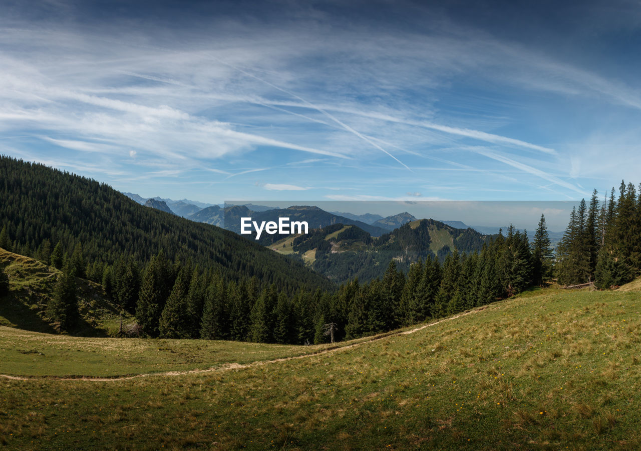 SCENIC VIEW OF GREEN LANDSCAPE AND MOUNTAINS AGAINST SKY