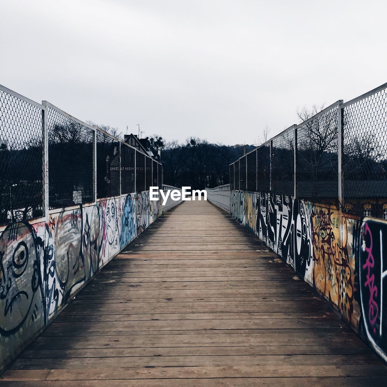 Narrow pathway along graffiti walls