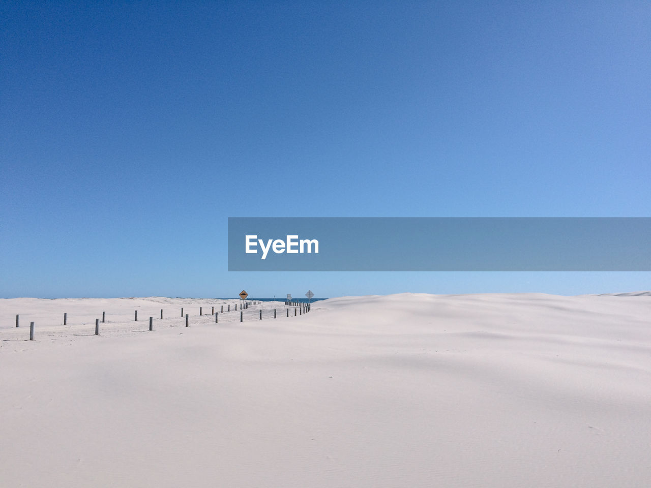 Scenic view of desert against clear blue sky