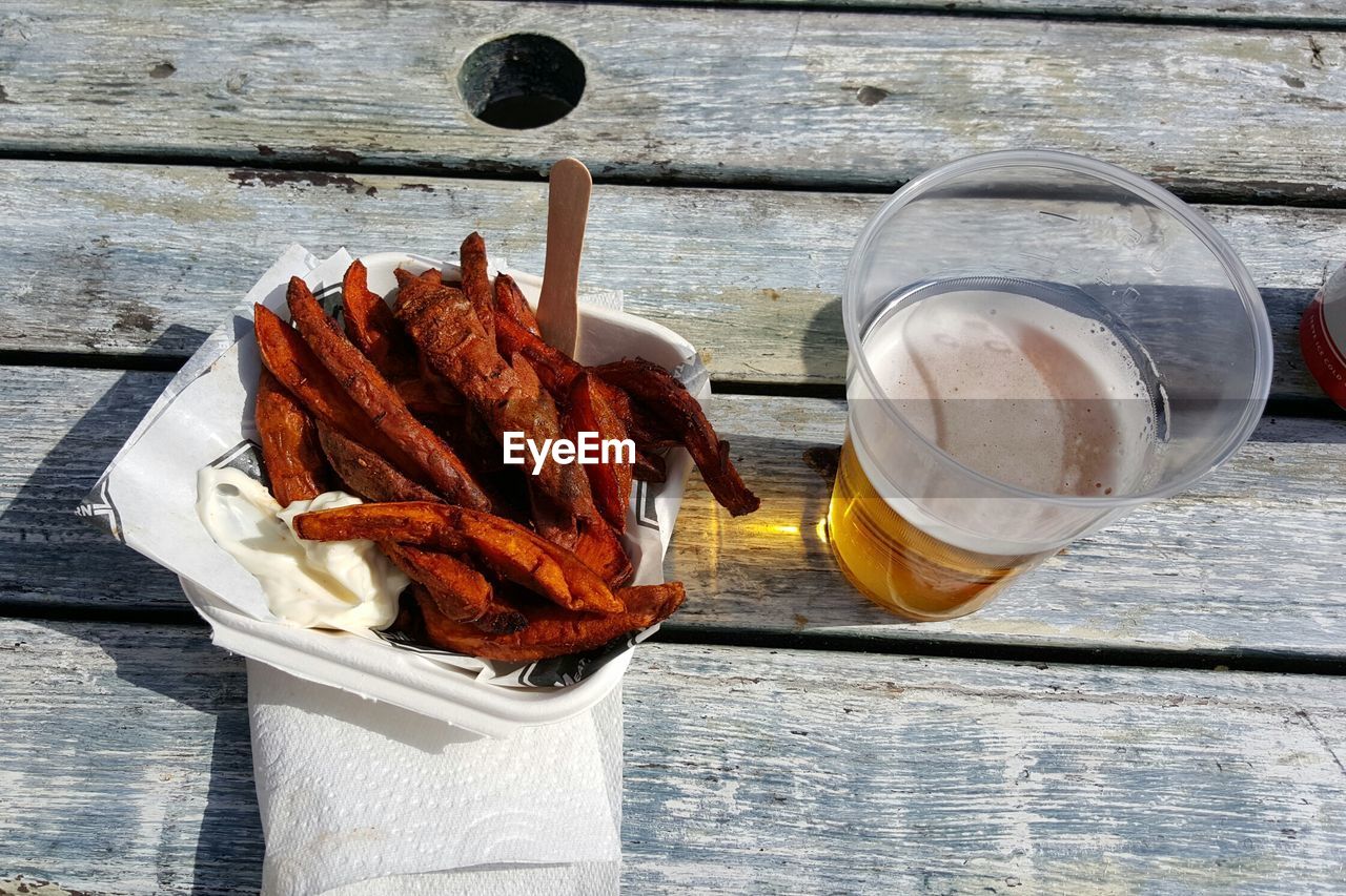 High angle view of fried sweet potatoes in beer on table