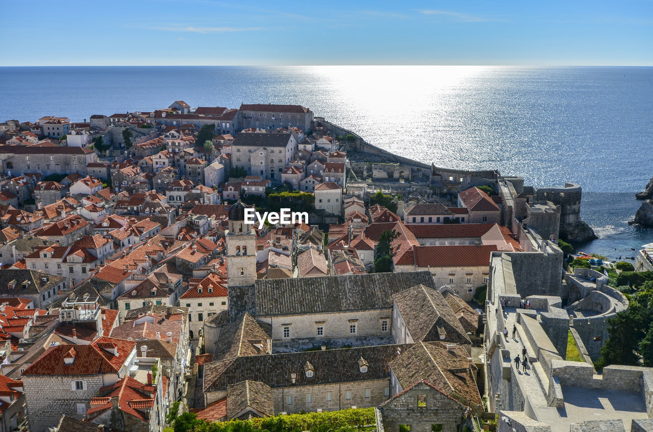 High angle view of townscape by sea against sky