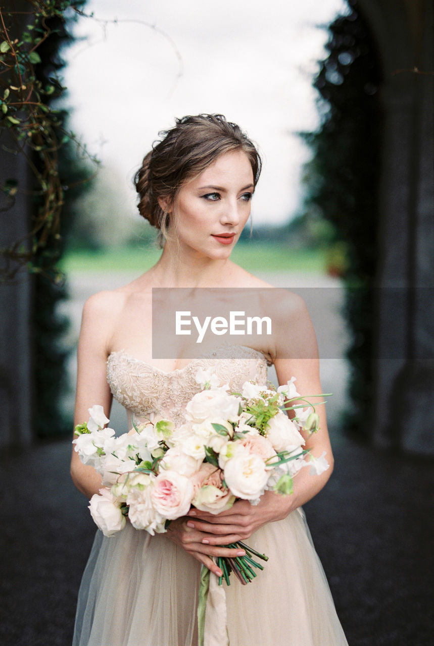 portrait of beautiful young woman standing in dress