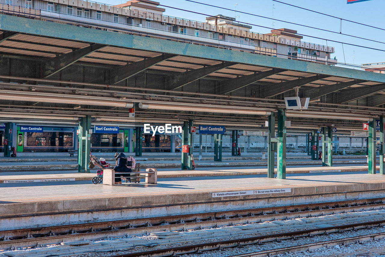train station, transport, rail transportation, railroad track, track, architecture, transportation, train, vehicle, built structure, mode of transportation, railway, railroad station, public transportation, railroad station platform, public transport, travel, day, group of people, city, building exterior, men, outdoors, nature, sky
