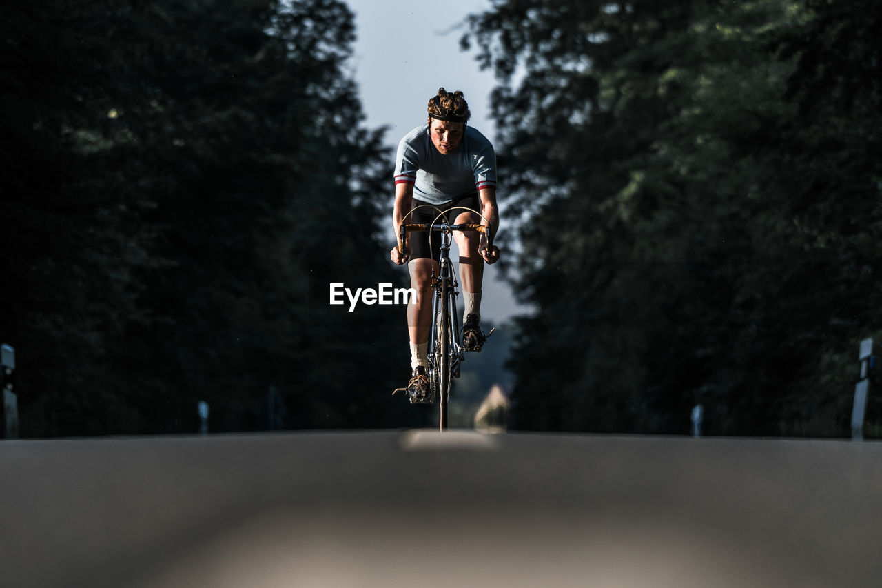 Young man riding bicycle on road