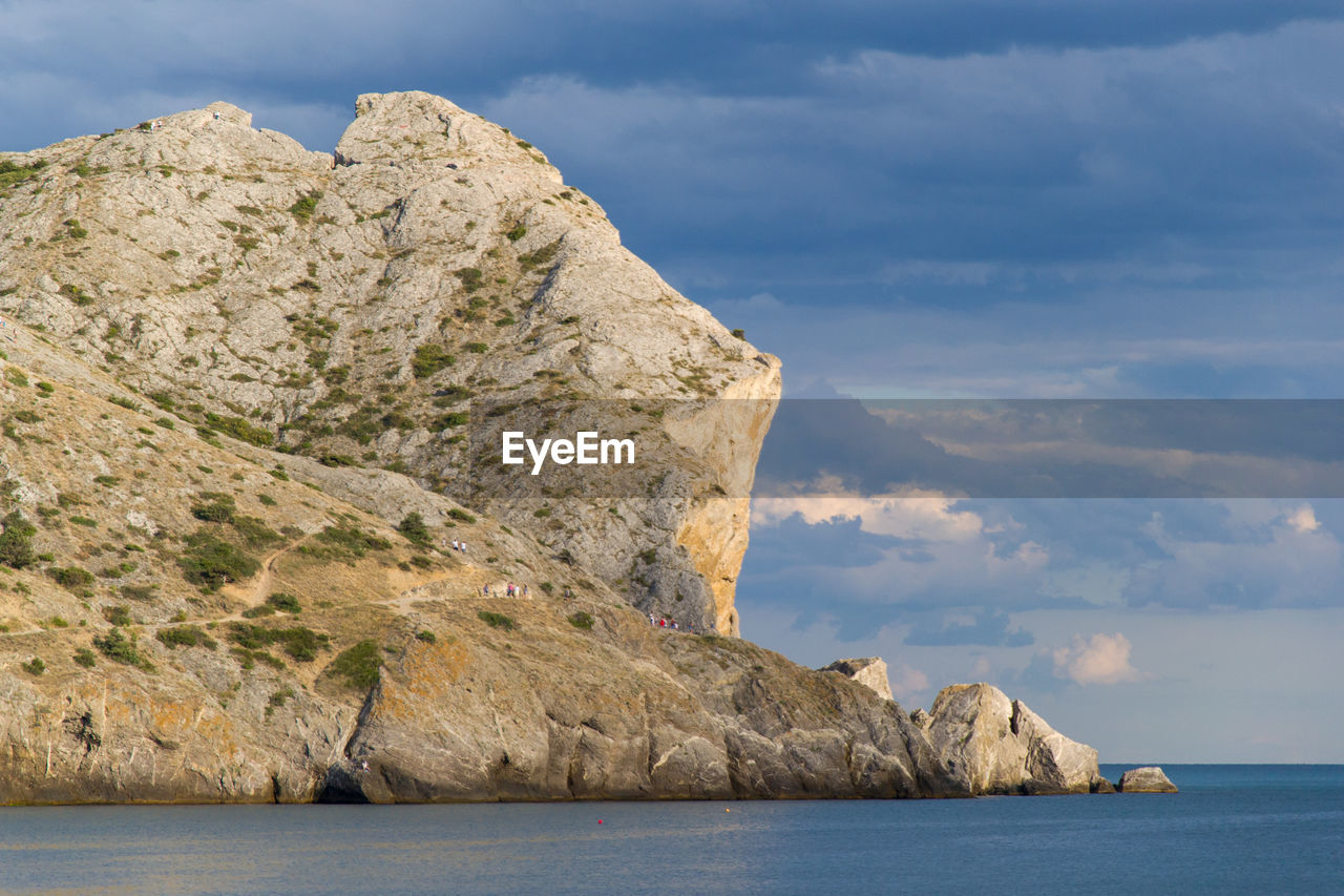 Rock formations by sea against sky