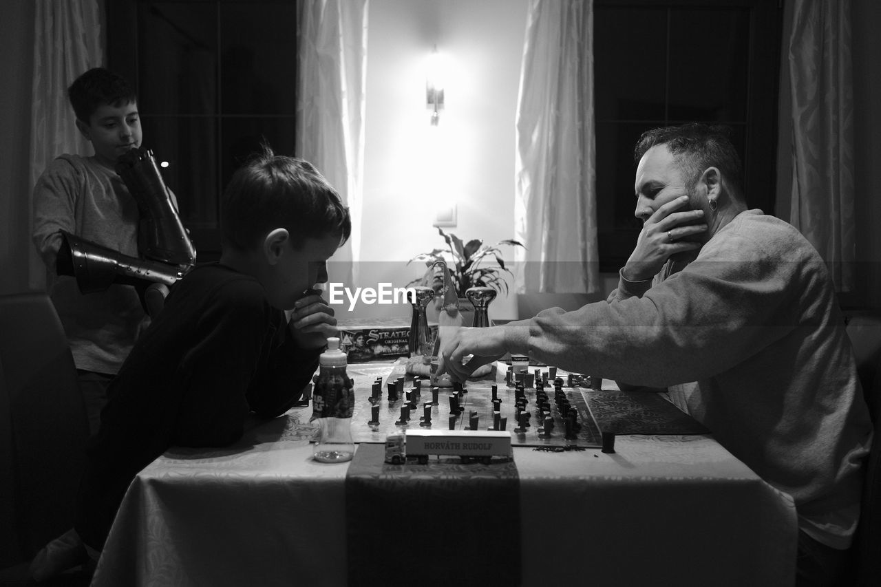 Father and son playing chess at home