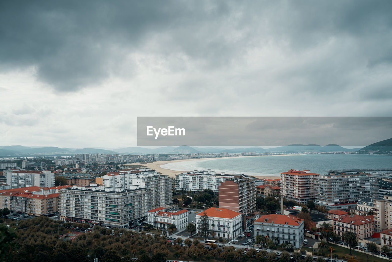 High angle view of buildings against sky in city next to beach