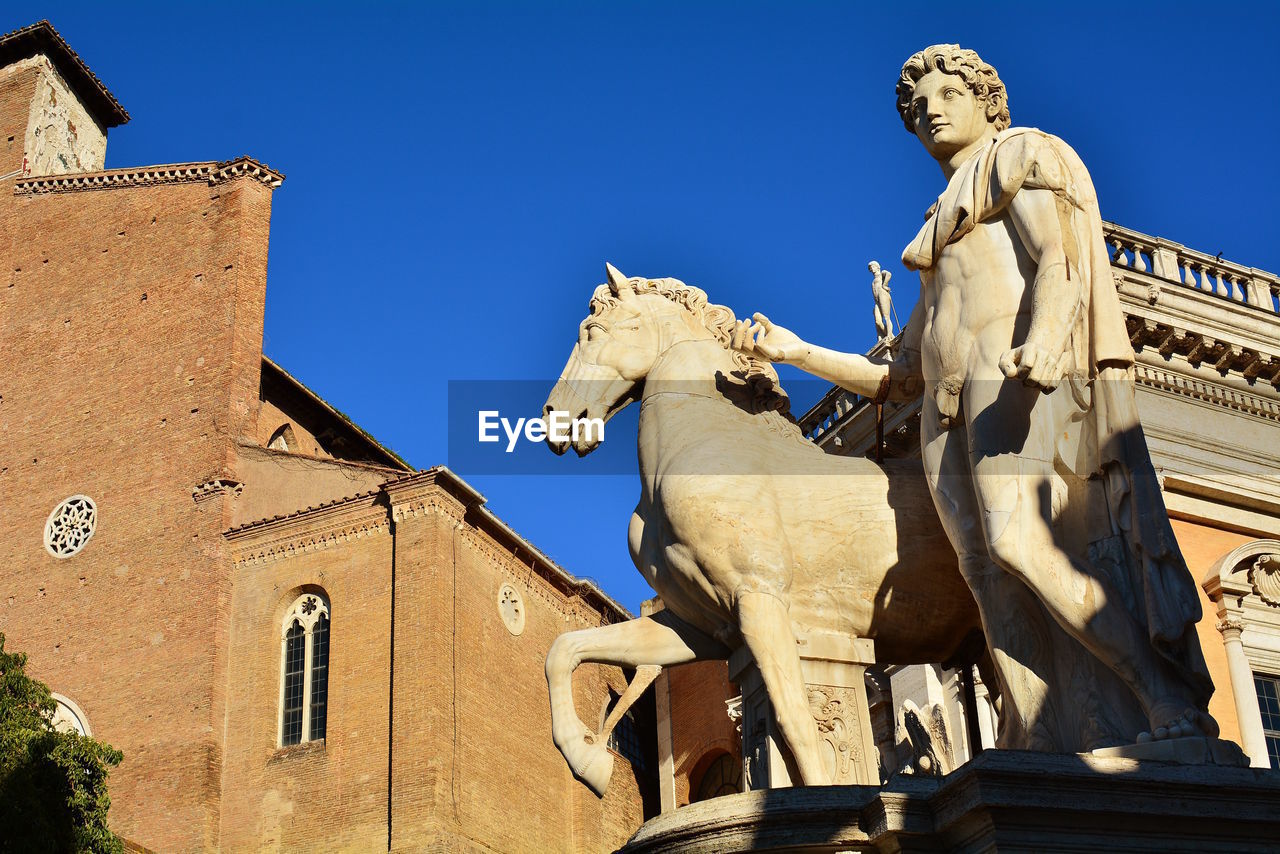 LOW ANGLE VIEW OF STATUE AGAINST HISTORIC BUILDING