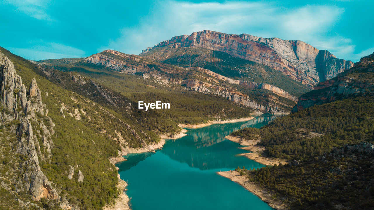 Scenic view of river amidst mountains against sky