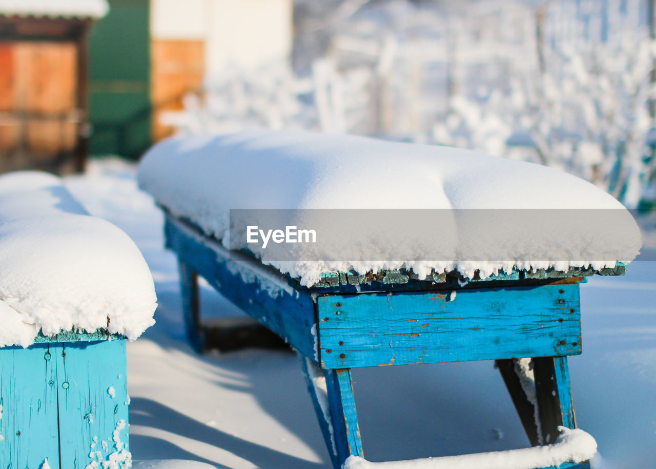 Close-up of frozen wooden bench during winter