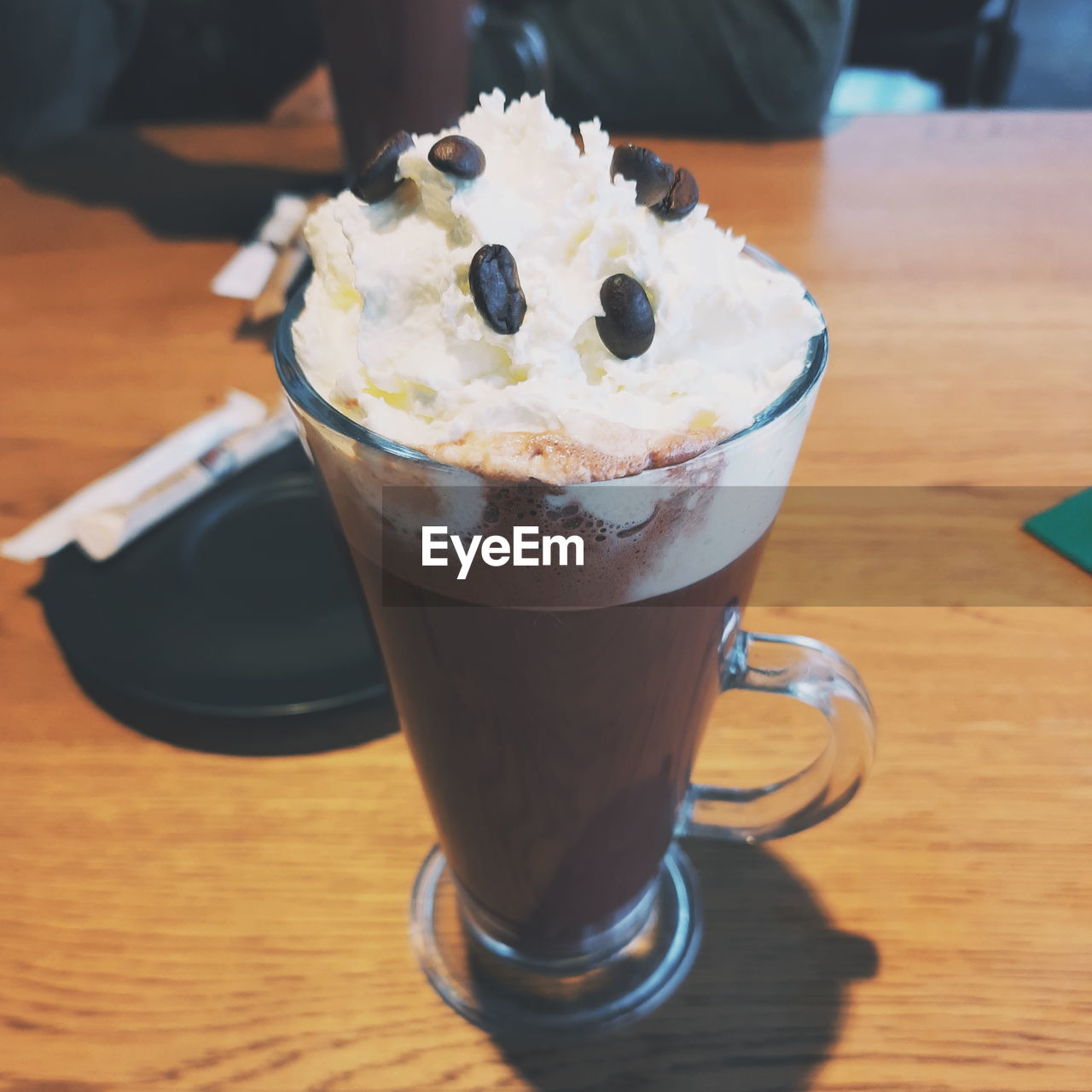 CLOSE-UP OF COFFEE IN GLASS ON TABLE