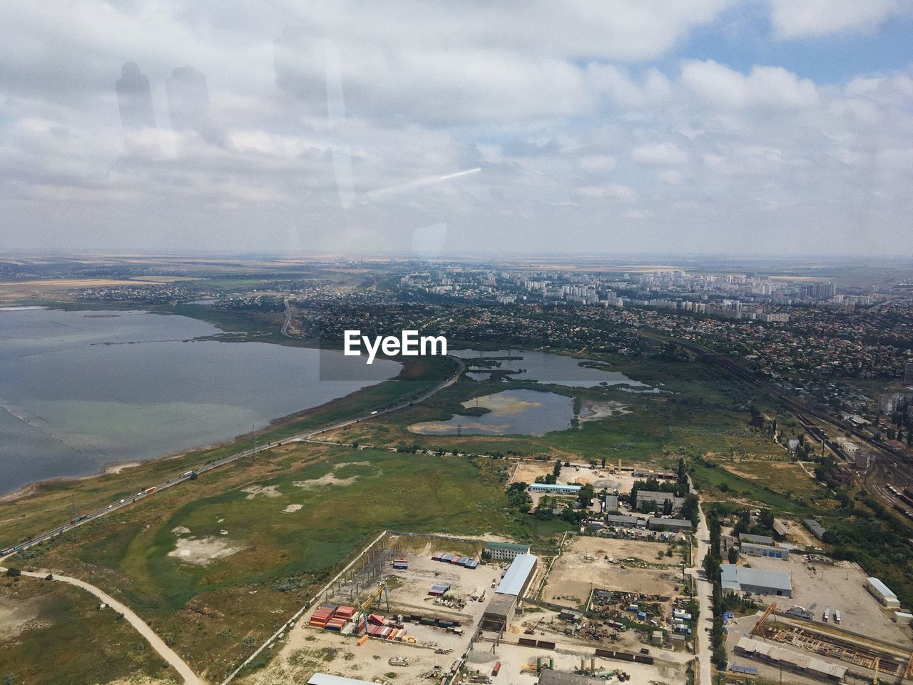 HIGH ANGLE VIEW OF RIVER BY BUILDINGS AGAINST SKY