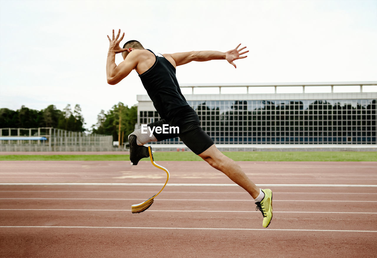 Full length of man jumping against the sky