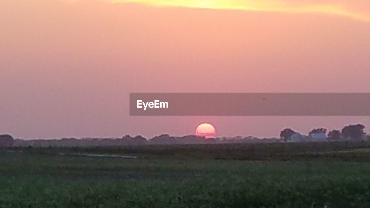 SCENIC VIEW OF FIELD AGAINST SKY AT SUNSET