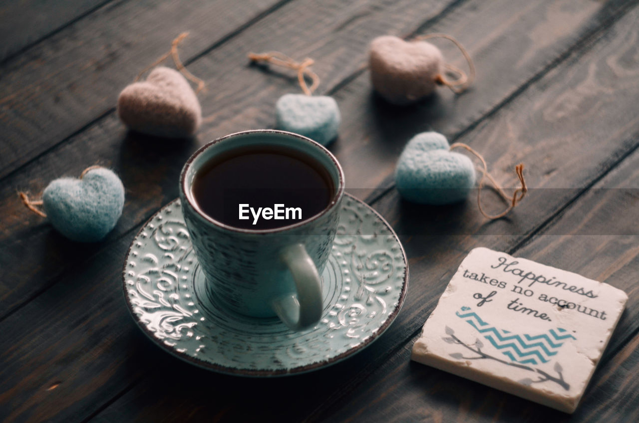 HIGH ANGLE VIEW OF COFFEE CUP ON WOODEN TABLE