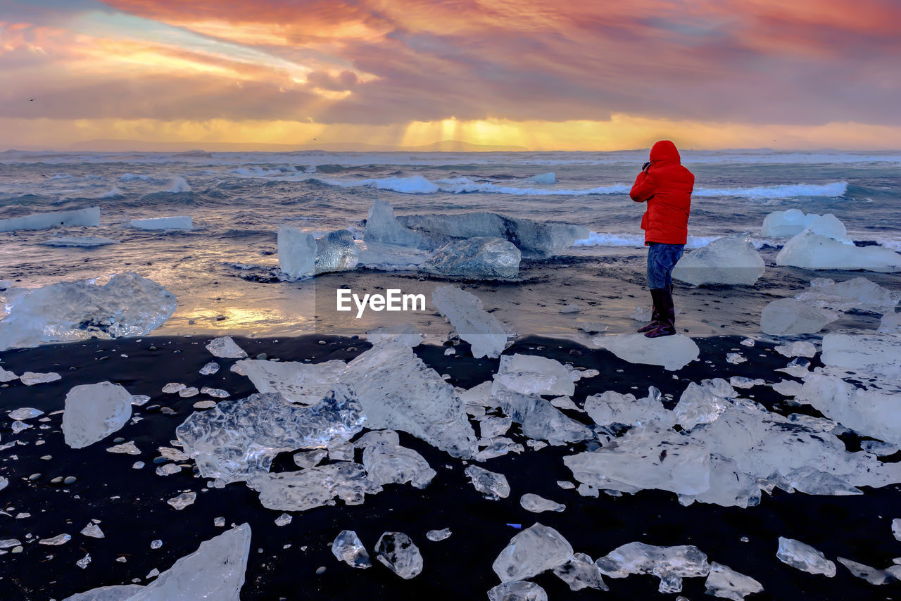 Full length of man standing on ice during sunset