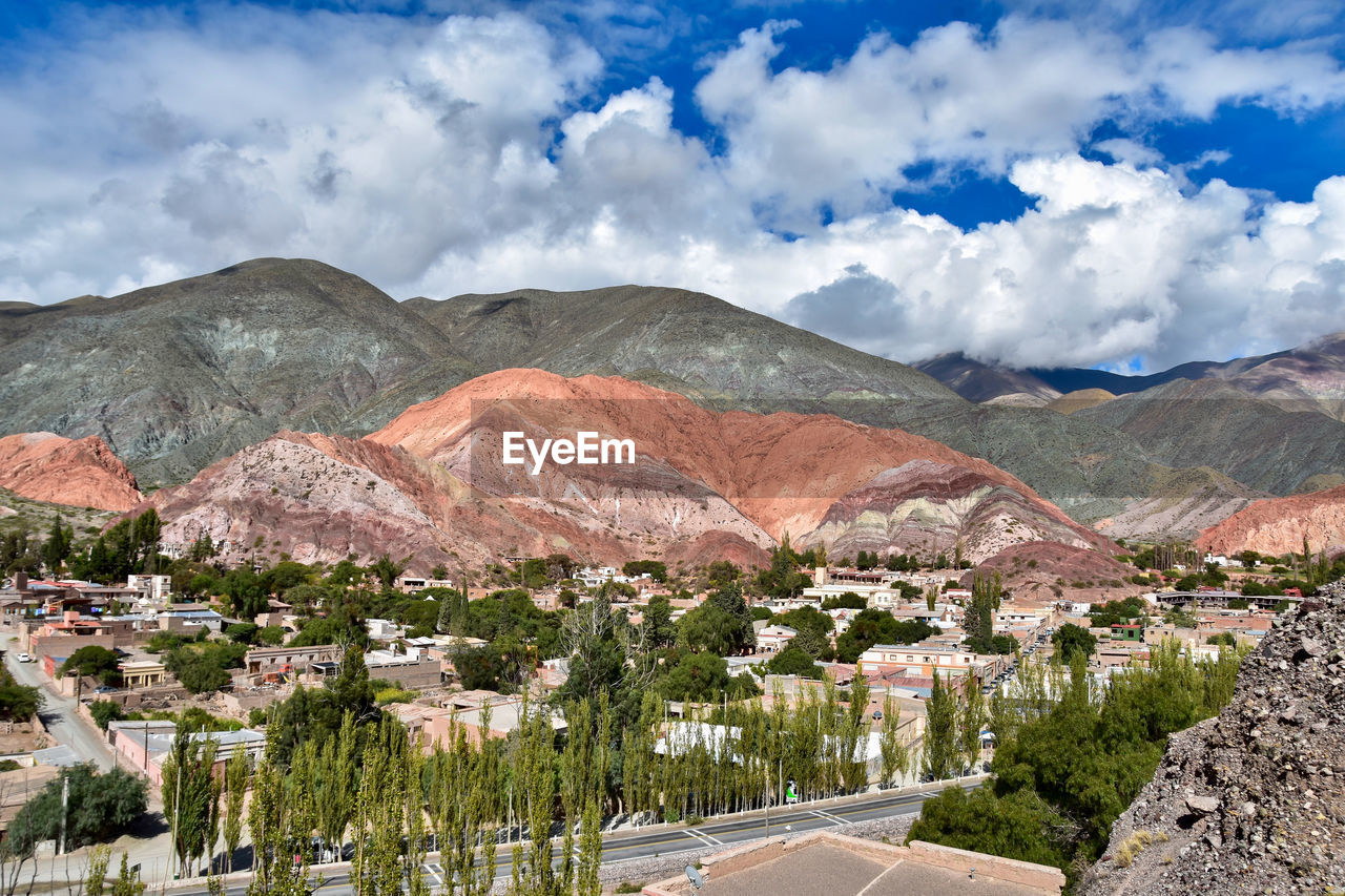 Panoramic shot of townscape by mountains against sky