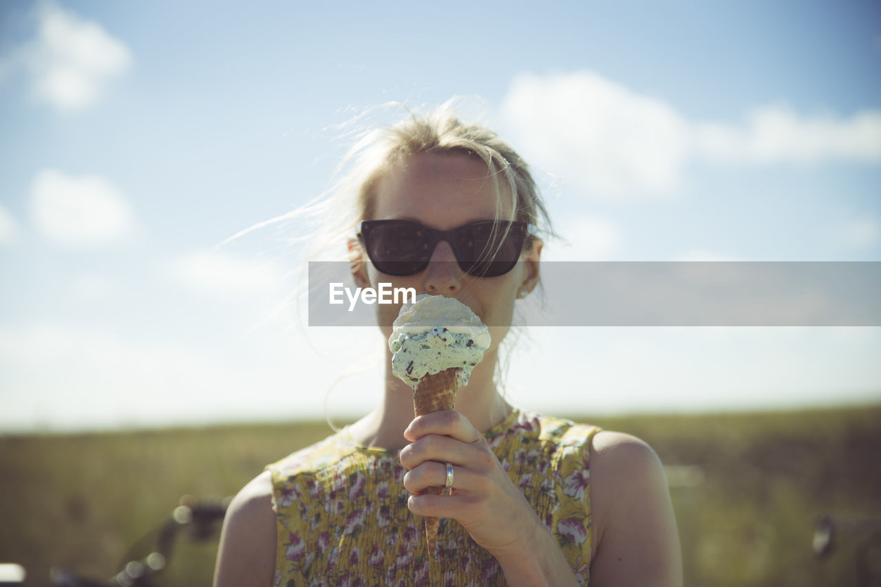 Blond woman with sunglasses eating ice cream