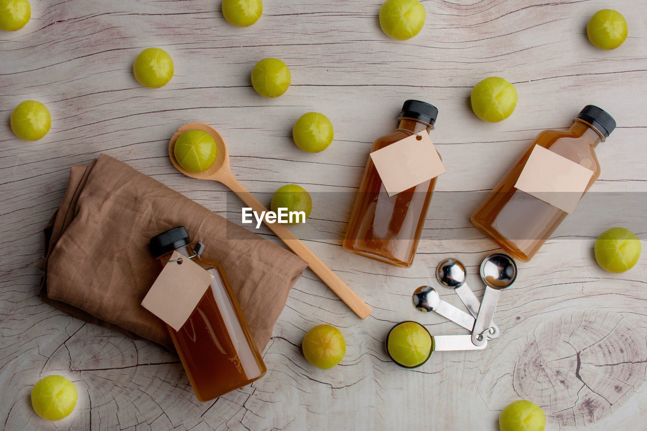 Fresh green amla or indian gooseberry fruits with gooseberry juice, healthy diet on wood table.