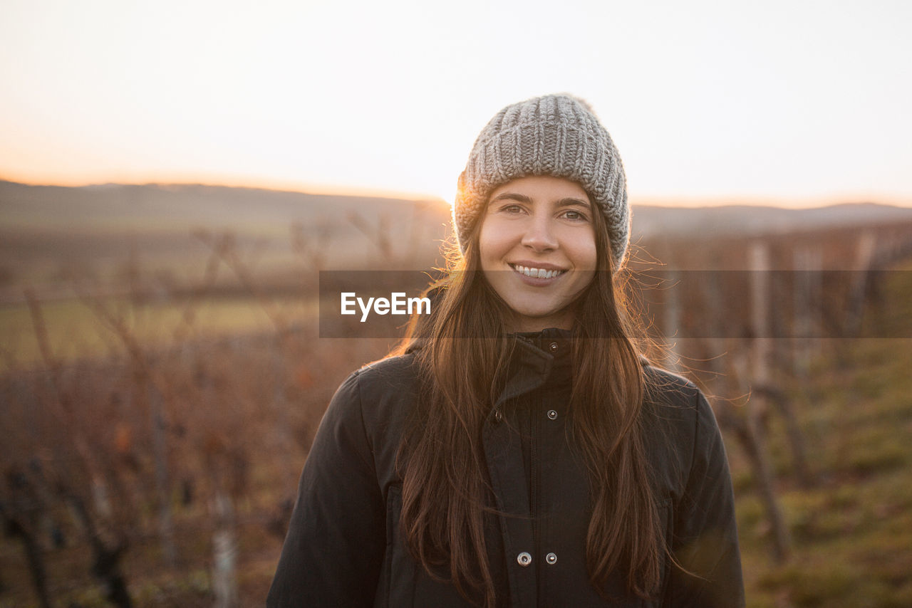 Portrait of a smiling young woman in vineyard in winter