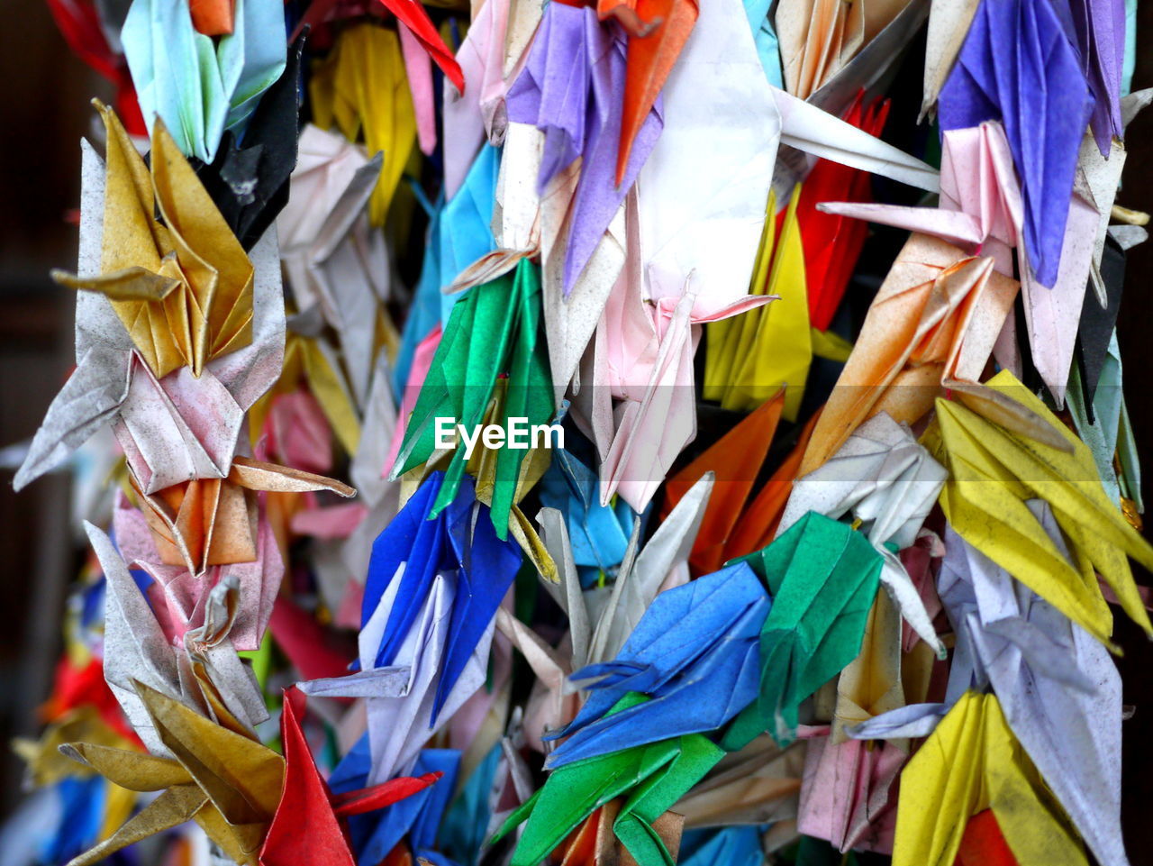 Colorful paper cranes hanging outdoors