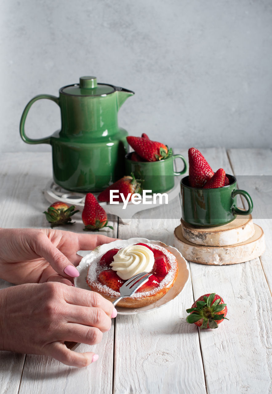 Fruit still life with strawberries and green tea set, strawberry cake with cream