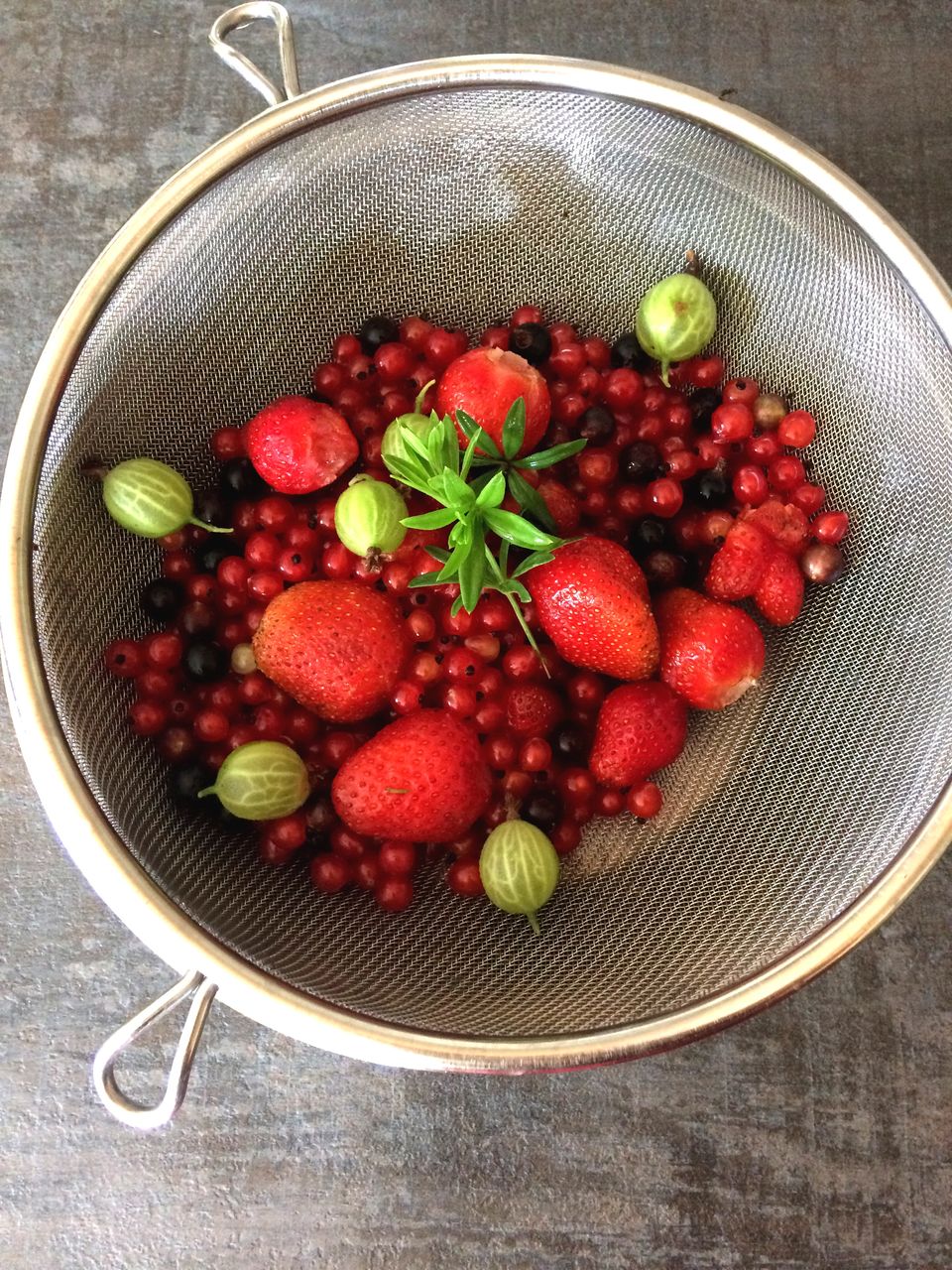 Directly above view of berry fruits in colander on table