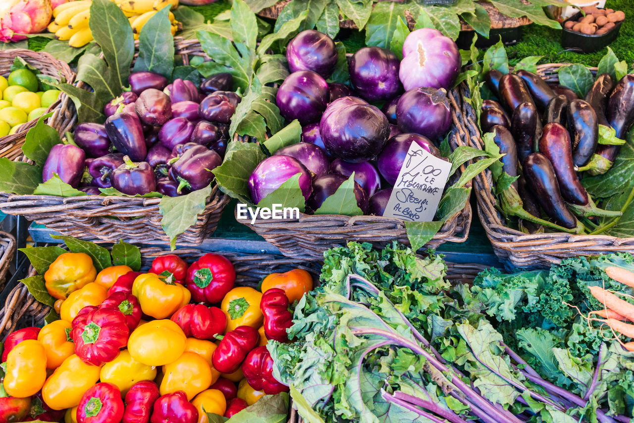 Eggplants at the vegetable market stall. various colourful vegetables in wicker basket