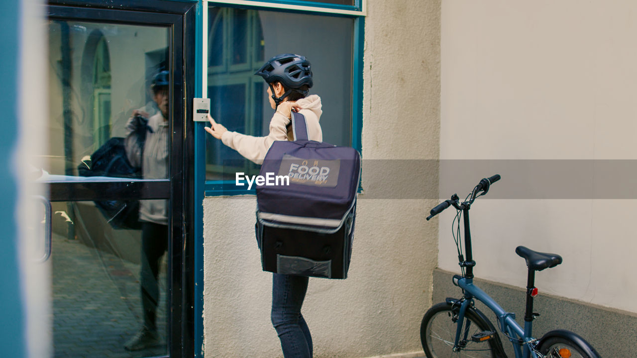 rear view of woman with bicycle on street