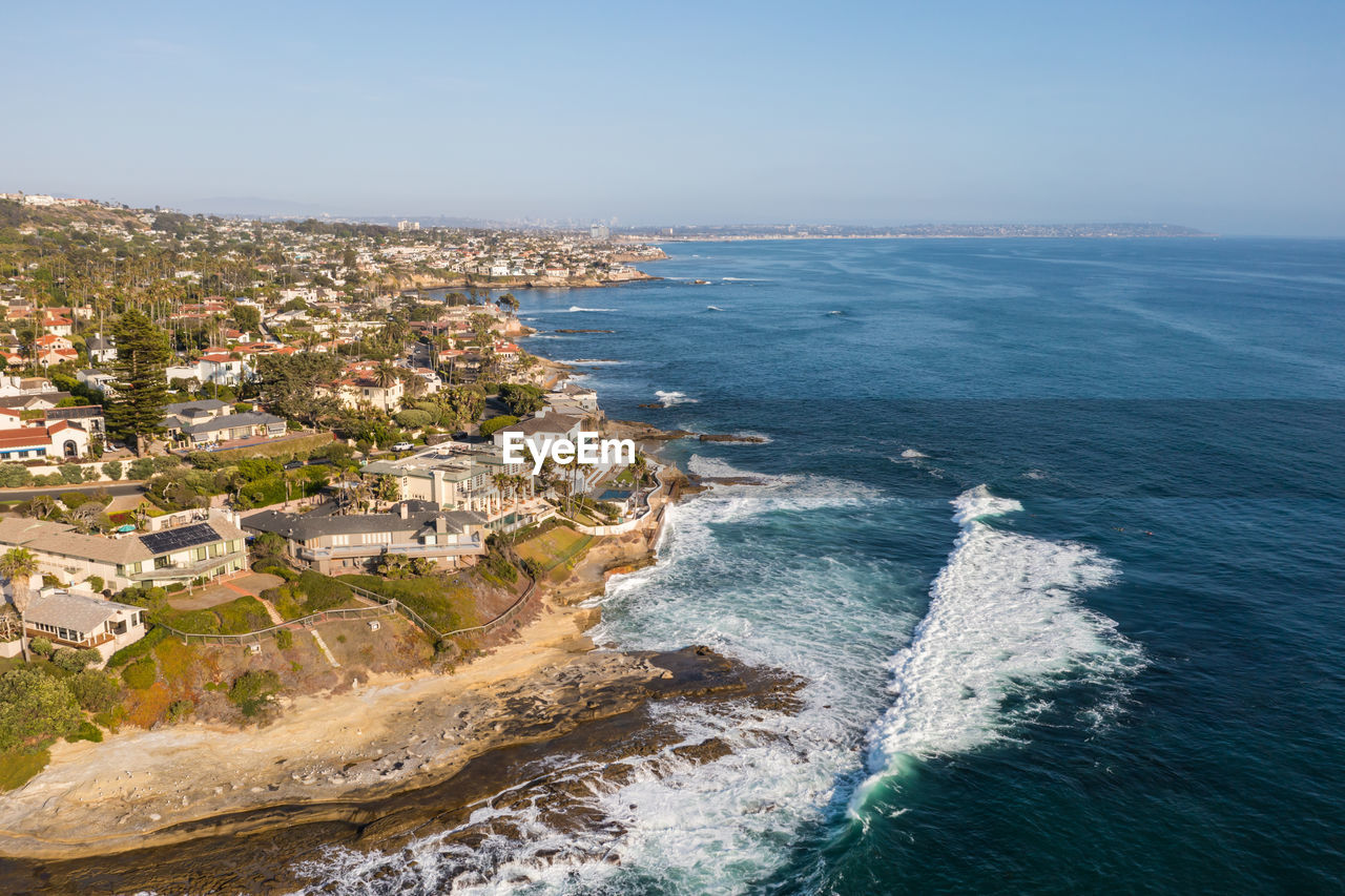 HIGH ANGLE VIEW OF BEACH AND BUILDINGS AGAINST SKY