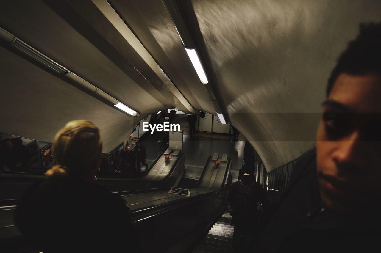 Portrait of man standing on escalator