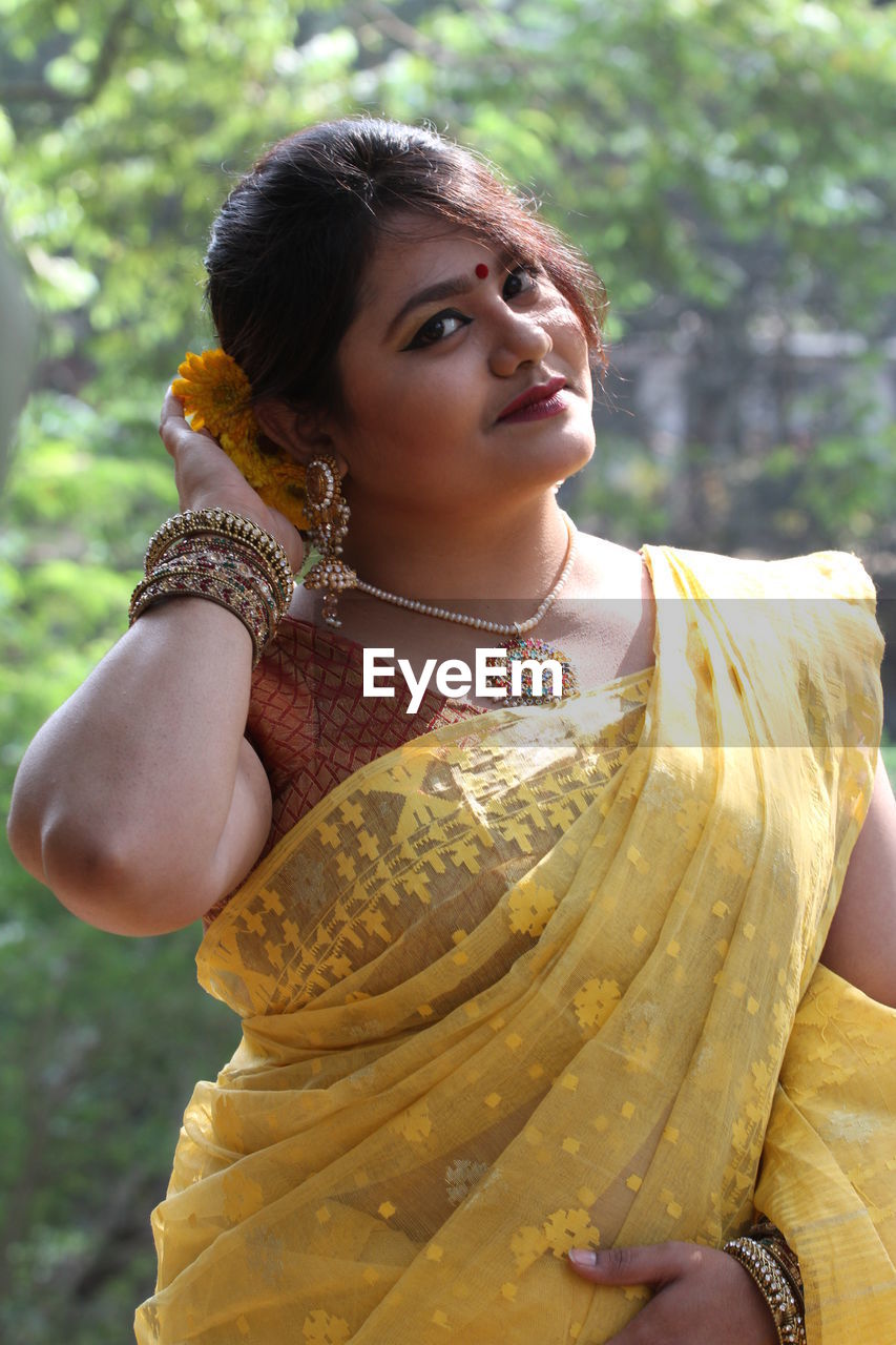 Portrait of smiling beautiful woman wearing yellow sari